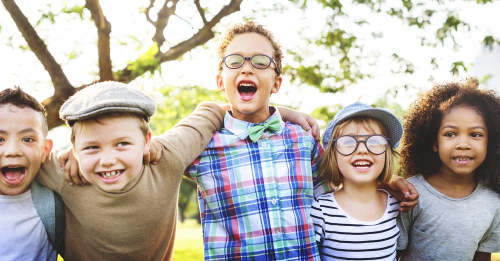 A group of diverse children smiling and holding each other